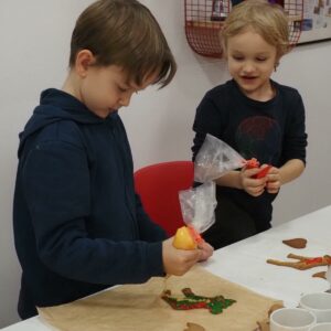 Zwei Buben der Geschwistergruppe verzieren Weihnachtskekse.