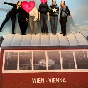 Sechs Teilnehmer stehen am Dach einer Gondel auf dem Riesenrad