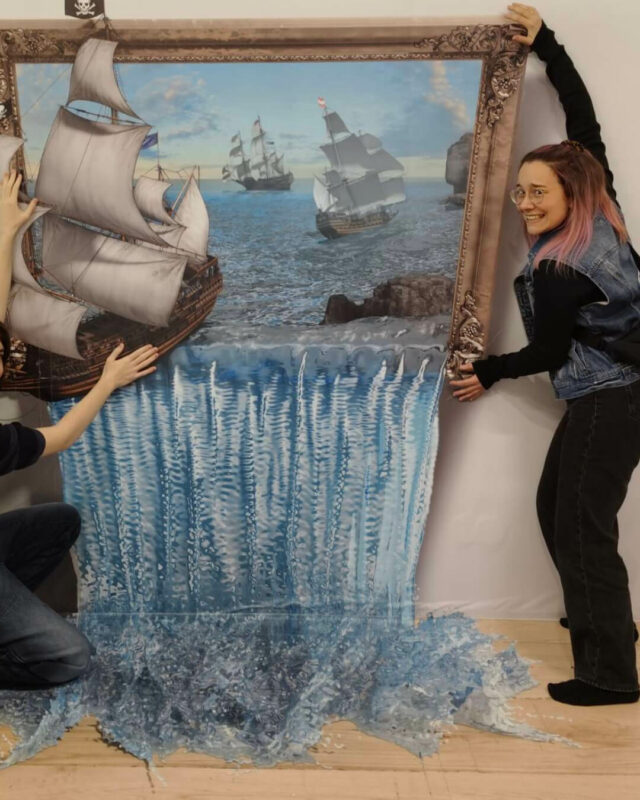 Zwei Frauen kippen ein Gemälde, wodurch Wasser und ein Segelschiff aus dem Bild fällt