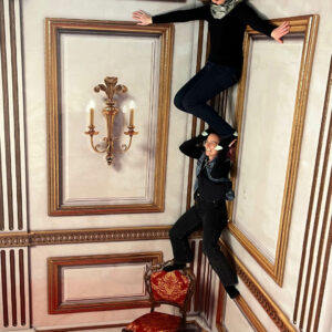 Zwei Frauen stehen in der Ecke eines Raumes waghalsig übereinander