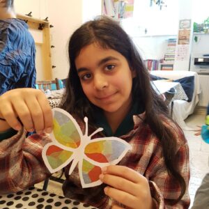 Mädchen präsentiert stolz selbst gebastelten Schmetterling