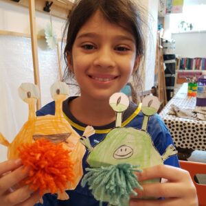 Mädchen zeigt ihre selbst hergestellten Monsterchen