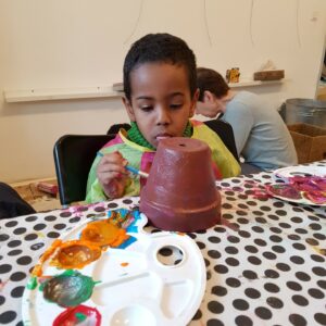 Bub bemalt Tontopf mit bunten Farben