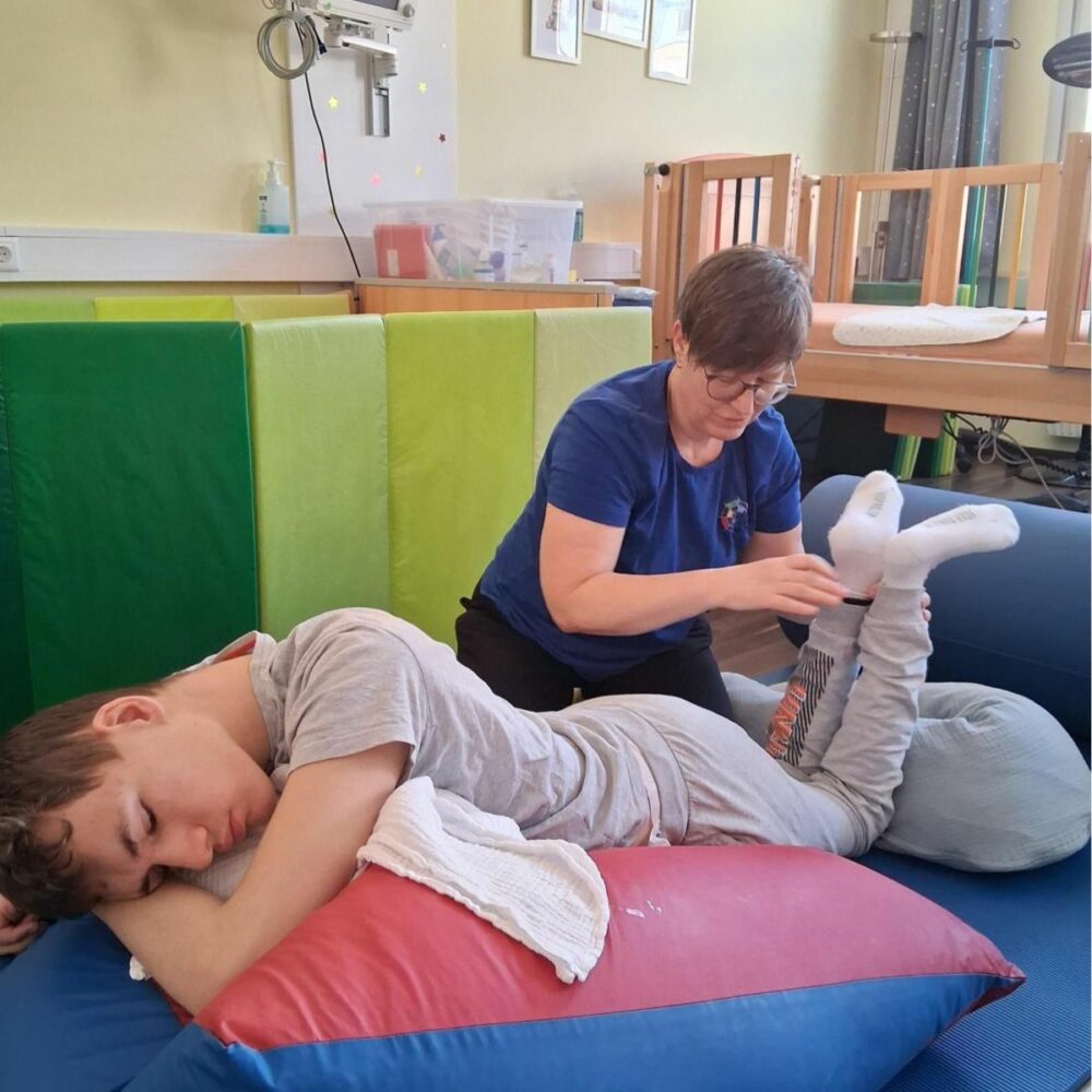 Eine Physiotherapeutin arbeitet mit einem Jugendlichen im Kindertageshospiz Netz.