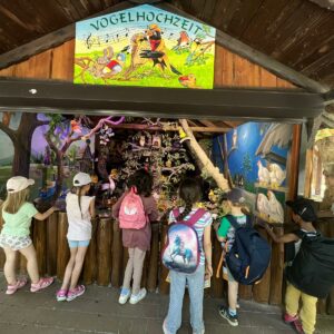 Sechs Kinder vor einem Stand zum Thema "Vogelhochzeit"
